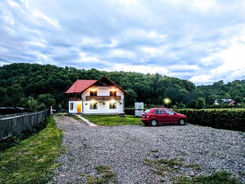 a red car parked in front of a house at Casa cu Aburi Sovata in Sovata