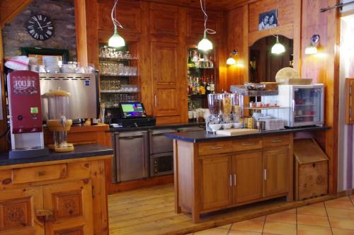 琴山朗勒堡的住宿－克雷德尚酒店，厨房配有木制橱柜和带酒吧的柜台。