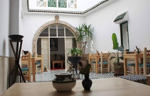 a room with a table with potted plants on it at Jennat El Mossafir-Riad privé avec services in Essaouira