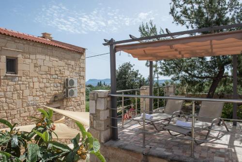 a patio with a table and chairs and a building at Pantanassa Villas in Agia Marina Nea Kydonias