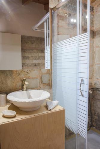 a bathroom with a sink and a glass shower at Pantanassa Villas in Agia Marina Nea Kydonias
