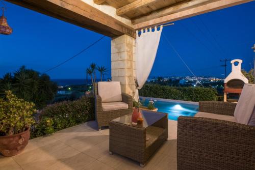 a patio with chairs and a view of the city at Pantanassa Villas in Agia Marina Nea Kydonias