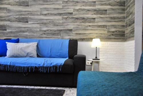 クラースナヤ・ポリャーナにあるV Italyanskom stileの青いソファと石壁のリビングルーム