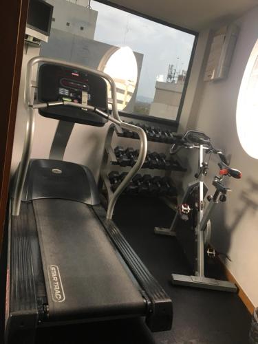 a gym with a treadmill and a simulator at Suites Contempo in Mexico City