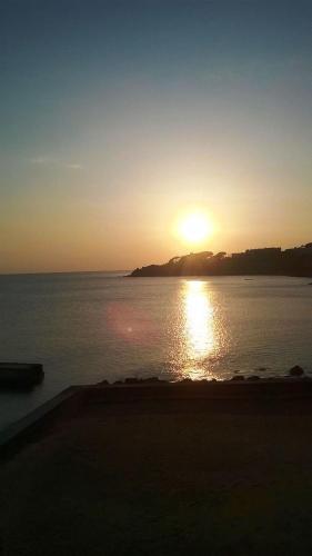 a sunset over a body of water with the sun setting at Villa MG Hotel in Santa Marinella