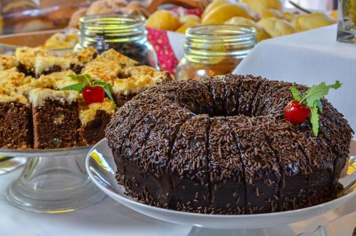 a chocolate cake on a plate on a table with other desserts at Vila Suzana Parque Hotel in Canela