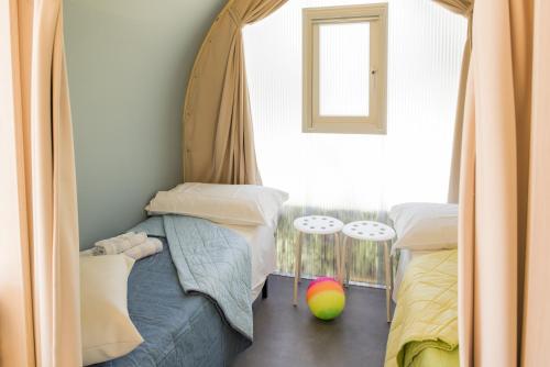 a bedroom with two twin beds and a window at La Rocca Camping Village in Bardolino