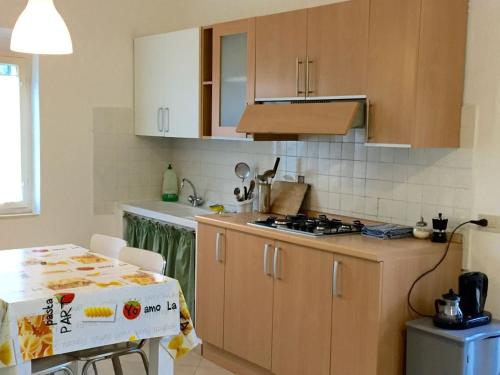 a kitchen with wooden cabinets and a table with a box at Casa Simonetta in Castellina Marittima