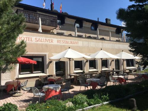 a restaurant with tables and chairs in front of a building at Hotel Saluver in Celerina