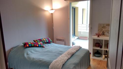 une chambre avec un lit avec des draps et des oreillers bleus dans l'établissement lille grand boulevard, à Marcq-en-Barœul