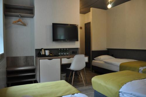 Zimmer mit 2 Betten und einem Schreibtisch mit einem TV in der Unterkunft Pokoje Zimna Woda in Rozalin