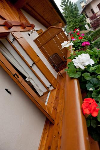a balcony with flowers on the side of a building at Agritur Renetta in Tassullo