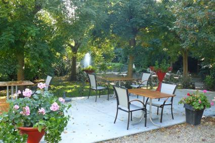- un ensemble de tables et de chaises dans un jardin fleuri dans l'établissement Aparthotel Malpertuus, à Aalst
