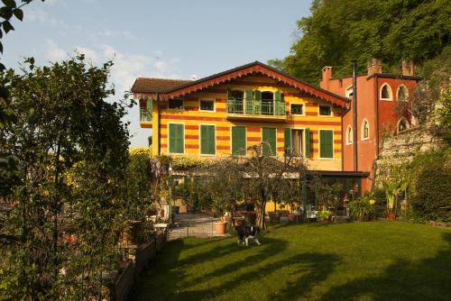 una casa con un cane seduto in giardino di Welcome Traveller VILLA ARIGONI a Garda
