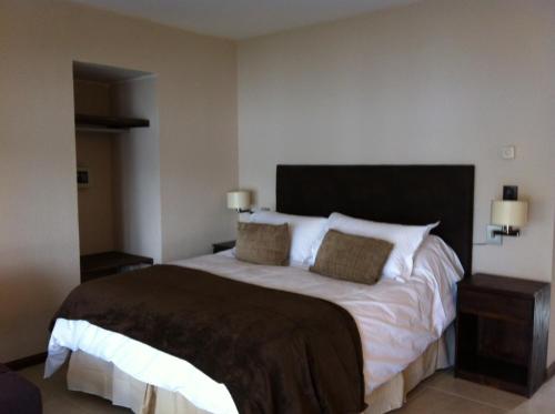 a bedroom with a large bed with two pillows at Orillas del Gutierrez in San Carlos de Bariloche