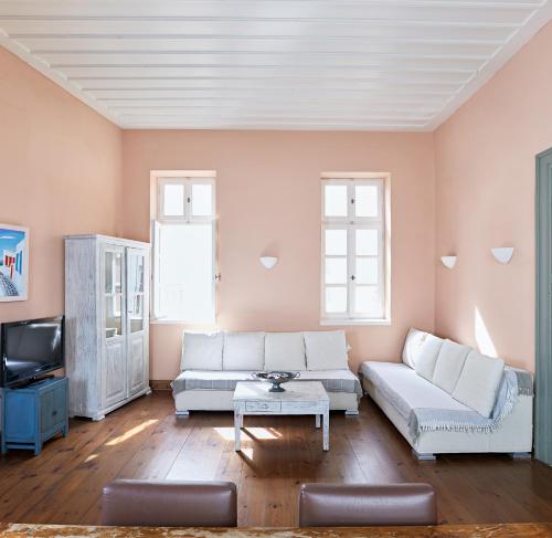 a living room with a couch and a tv at Guesthouse Lila in Ermoupoli