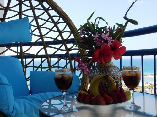 - une table avec deux verres de vin et des fleurs dans l'établissement Avrora Luxury Apartment, à Ashkelon