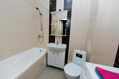 a bathroom with a sink and a toilet and a bath tub at City Center Apartment on Pochtovy 4 in Orenburg