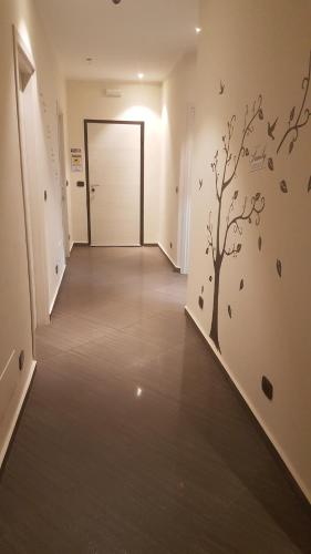 a hallway with a tree and birds on the wall at Civico 83 in Reggio Calabria
