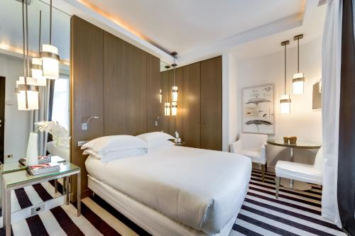 a bedroom with a large white bed and a desk at Le A in Paris