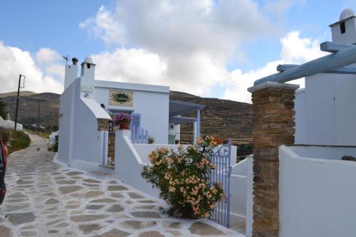 a white building with a fence and a plant at Studio Ioanna Tinos in Kionia