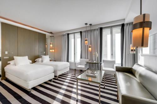 a hotel room with two beds and a couch at Le A in Paris