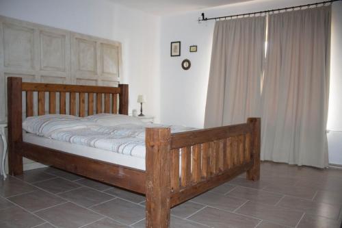1 cama en un dormitorio con marco de madera en Holiday Home Melinda, en Ceglédpuszta