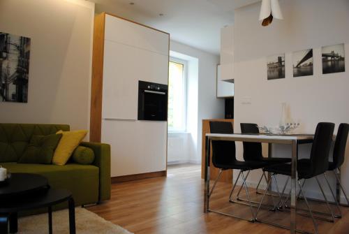Apartament Zwycięstwa 98 في كوشالين: غرفة معيشة مع أريكة خضراء وطاولة