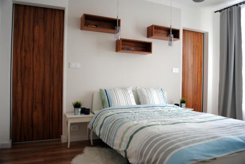 a bedroom with a bed and a night stand with a table at Apartament Zwycięstwa 98 in Koszalin