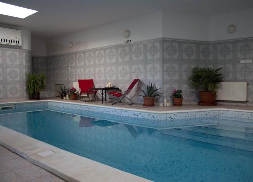 een zwembad met twee stoelen en een tafel ernaast bij Holiday Home Melinda in Ceglédpuszta
