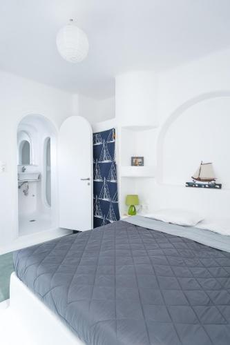 a bedroom with a large bed with white walls at Merchia Bay Villas Mykonos in Merchia Beach