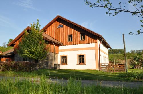 a large white house with a wooden roof at Apartmán Kamenný Dům in Jilemnice