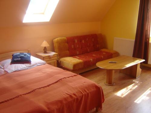 a bedroom with a bed and a couch and a table at Ośrodek Wczasowy Wierchy in Korbielów