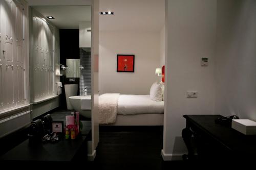 een badkamer met een slaapkamer met een bed en een wastafel bij Manna in Nijmegen