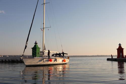 a sailboat with a man and a dog on it in the water at Hostel Adriatic Piran in Piran