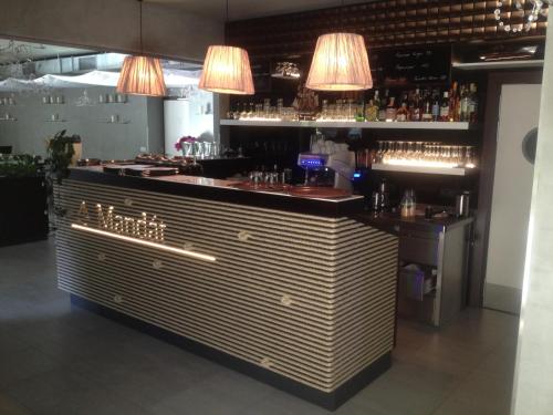 a bar in a restaurant with lights above it at Hotel Mandát in Hradištko