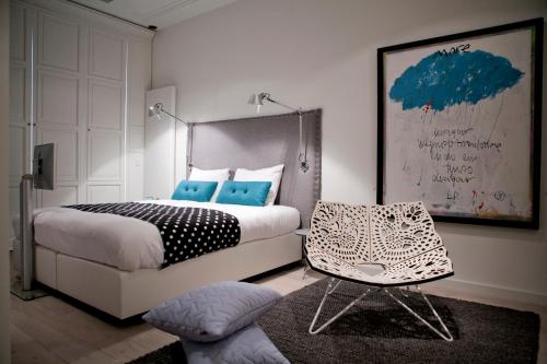 a bedroom with a bed and a chair in it at Hotel Manna in Nijmegen