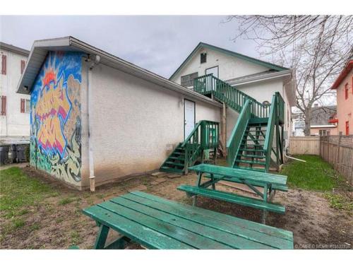 two green benches in front of a building with a mural at Kelowna Okanagan Lake Hostel in Kelowna