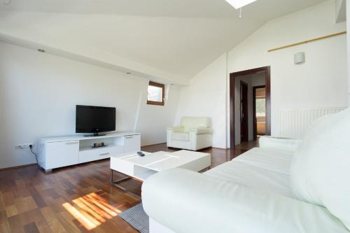 a white living room with a bed and a tv at Beautiful View Of Sarajevo Center in Sarajevo