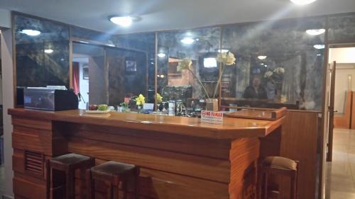 a bar in a restaurant with a counter and chairs at Apart Hotel Magali in Córdoba
