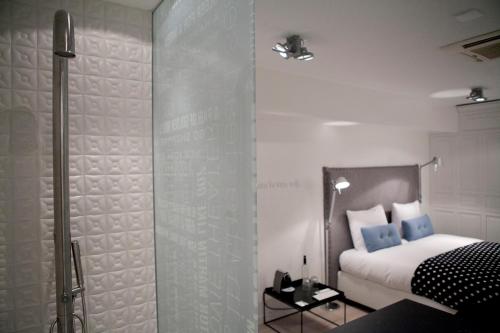 a bedroom with a bed and a glass shower at Hotel Manna in Nijmegen
