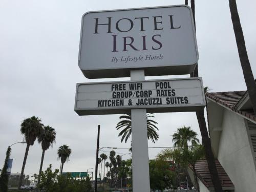 a hotel iris sign on a street with palm trees at Hotel Iris - Mission Valley-San Diego Zoo-SeaWorld in San Diego