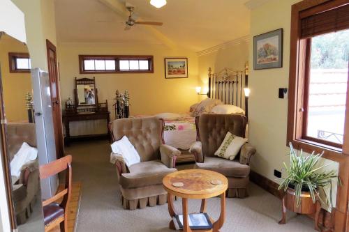 a living room with chairs and a bed and a table at McCloud House in Port Noarlunga