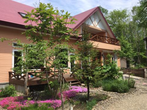 a house with flowers in front of it at Forestlodge Subaru in Teshikaga