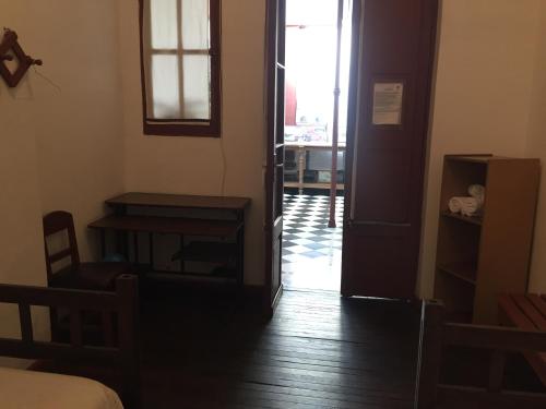 a room with a door and a table and a desk at Posada Casa de Borgoña in Salta