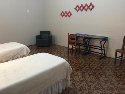 a room with two beds and a desk and a chair at Posada Casa de Borgoña in Salta