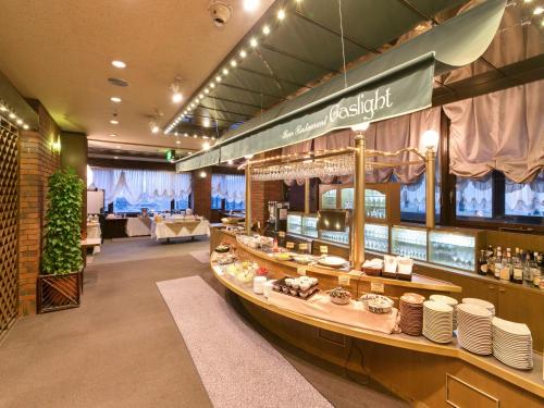 a restaurant with a counter with dishes on it at Yamagata Nanokamachi Washington Hotel in Yamagata