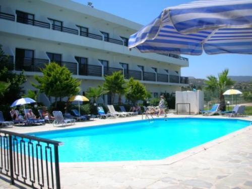 una piscina con sombrilla y un hotel en Souli Beach Hotel en Polis Chrysochous