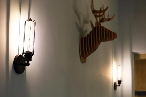 a light on a wall with two deer heads on it at Taroko Mountain View B&B in Shunan