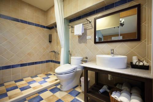 a bathroom with a toilet and a sink and a mirror at Taroko Mountain View B&B in Shunan